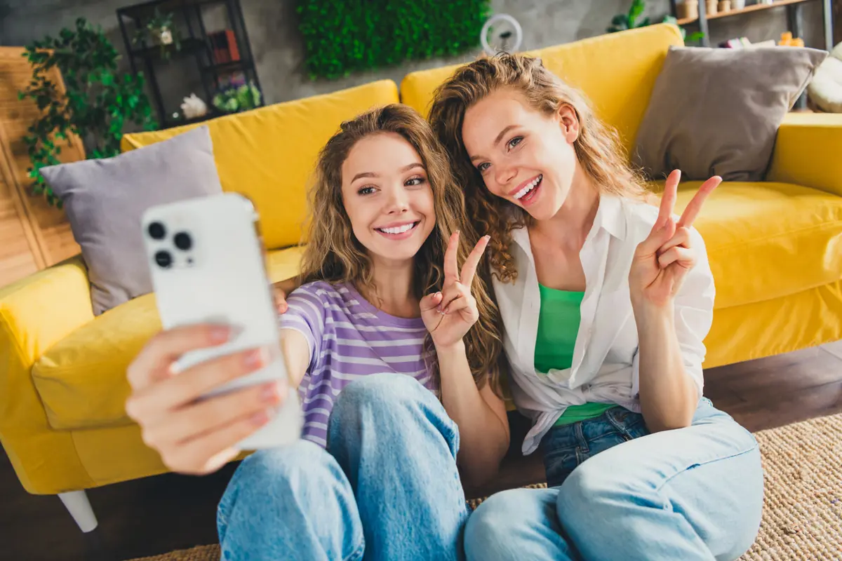 2 blije vrouwelijke huurders maken selfie met telefoon